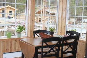 a dining room with a table and chairs and windows at Trasti & Trine Boutique Hotel in Alta
