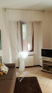 ein Wohnzimmer mit einem Sofa und einem Fenster in der Unterkunft Appartamento Vecchia Domo in Domodossola