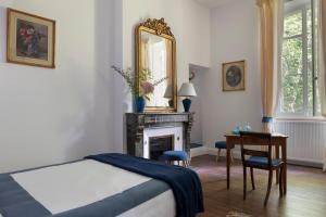 - une chambre avec un lit, un miroir et une table dans l'établissement Château Le Méjean, à Pessac-sur-Dordogne