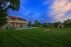 una casa con un ampio cortile con una grande piscina di Villa Marija a Marčana