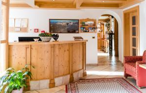 a living room with a wooden counter and a red couch at Garni Hotel Iris in Selva di Val Gardena