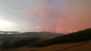 a rainbow in the sky over a mountain at Curry's Post Bed & Breakfast in Curryʼs Post