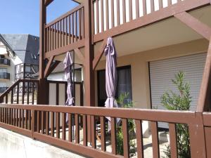 two closed umbrellas on a balcony of a house at Appartements Blonville Centre (2 ou 3 chambres) in Blonville-sur-Mer
