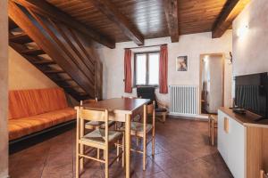 - une salle à manger avec une table et un canapé dans l'établissement Residence La Tana del Ghiro, à Bardonnèche