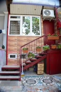 a house with stairs and potted plants on it at Stumari Apartaments in Tbilisi City