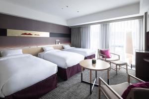 a hotel room with two beds and a table at Cross Hotel Kyoto in Kyoto +59 photos