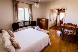 1 dormitorio con 1 cama blanca y 1 silla en Villa Carmen Lanzarote, en Costa Teguise