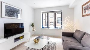a living room with a couch and a tv at Oxford Circus Apartments in London