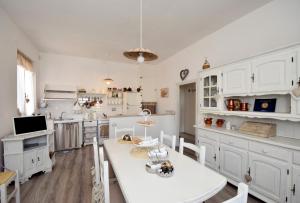 a kitchen with white cabinets and a white table at Shabby House Nonna Peppa in Campello sul Clitunno
