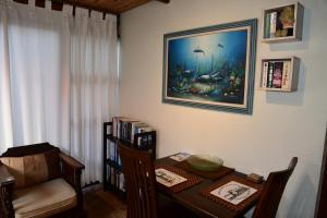 a dining room with a table and a painting on the wall at Bradclin House in Cape Town