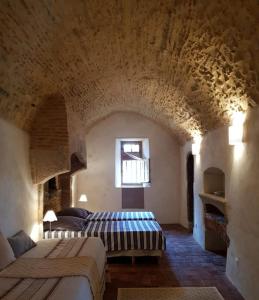 ein großes Schlafzimmer mit 2 Betten in einer Steinmauer in der Unterkunft Manoir au sein du village in Saint-Haon-le-Châtel