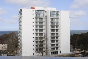a tall white building with windows at Wechta E5 in Międzyzdroje