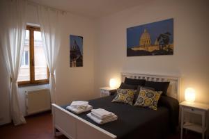 a bedroom with a bed with two lamps and a window at Vista Cupola House in Rome