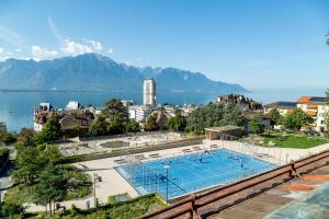 a swimming pool with a view of the water and mountains at Les Amandiers in Montreux