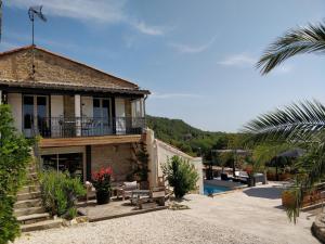 een huis met een balkon en een zwembad bij Gîte d'Emma in Lauret