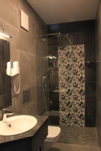 a bathroom with a shower, sink, and mirror at Hotel Eulensteins in Jena