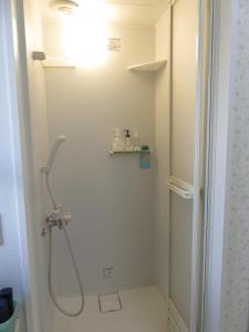 a bathroom with a shower with a shower head at Hostel Kamakura in Kamakura