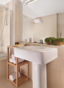 ein Badezimmer mit einem weißen Waschbecken und einer Dusche in der Unterkunft Elefsina Hotel in Eleusis