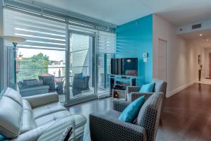 een woonkamer met een bank en stoelen en een tv bij Les Immeubles Charlevoix - Le 760504 in Québec