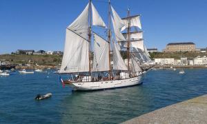 um veleiro na água ao lado de uma doca em Homedisa em Saint-Pair-sur-Mer