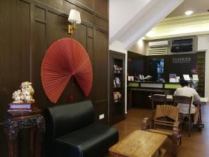 Zimmer mit einem Stuhl, einem Regenschirm und einem Tisch in der Unterkunft Jonker Boutique Hotel in Malakka