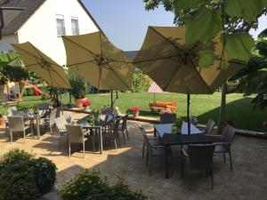 a patio with tables and chairs with umbrellas at Bed and Breakfast - Rheingauer Hof in Oestrich-Winkel +12 photos