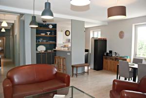 a living room with a leather chair and a table at Gite de Mougeres in Caux