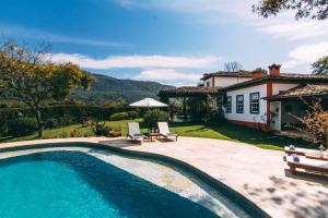 a swimming pool in front of a house at Amana Tiradentes in Tiradentes