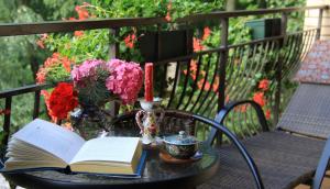 an open book on a table with a candle and flowers at Boutique Vila Artemide in Palanga