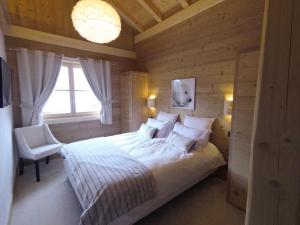 Un dormitorio con una cama grande y una ventana en Chalet Nanook, en Notre-Dame-de-Bellecombe