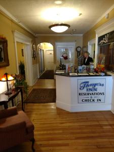 a woman standing behind a counter in a room at Thayers Inn in Littleton