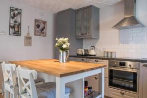 a kitchen with a table with a vase of flowers on it at Country Nest in Carnwath