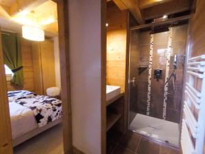 a bathroom with a shower and a sink next to a bed at Chalet Nanook in Notre-Dame-de-Bellecombe
