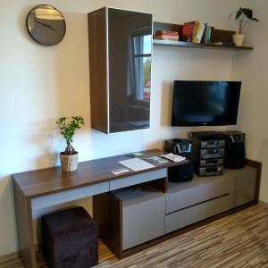 a room with a desk with a tv and a tv at Apartamenty Słupsk in Słupsk