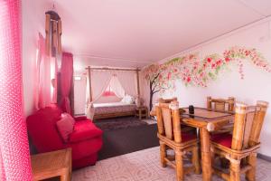 a living room with a table and a red couch at Ambalabaa in Saint-Philippe
