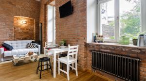 a living room with a white table and a brick wall at Miodowe mieszkanko in Krakow