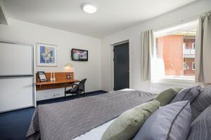 Schlafzimmer mit einem Bett, einem Schreibtisch und einem Fenster in der Unterkunft OnlySleep Trafikcenter in Slagelse