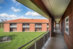 een balkon met uitzicht op een gebouw met een grasveld bij OnlySleep Trafikcenter in Slagelse