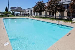 a large blue swimming pool with chairs in front of a building at Quality Inn & Suites in Saginaw