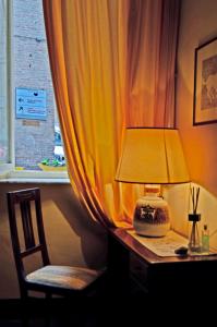 a desk with a lamp and a chair next to a window at Casa di Luli in Siena