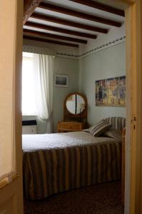 a bedroom with a bed and a mirror and a window at Casa di Luli in Siena