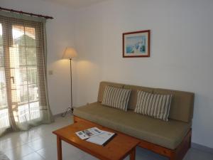 a living room with a couch and a coffee table at Apartamentos Villa Primera in Cala Figuera