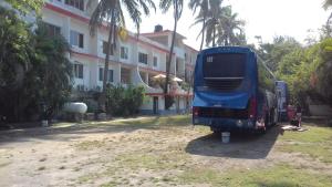 einem blauen Bus, der vor einem Gebäude parkt in der Unterkunft Hotel Playa Azul in Playa Azul