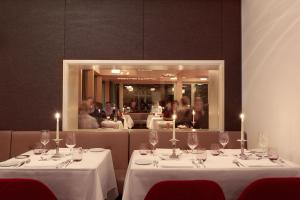 ein Esszimmer mit 2 Tischen und Weingläsern in der Unterkunft Bellevue Parkhotel & Spa - Relais & Châteaux in Adelboden