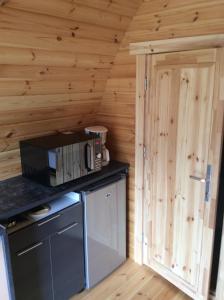 een keuken met een magnetron en een houten muur bij POD des deux chênes in Louroux-Hodement