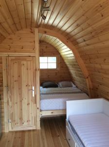 a bedroom in a log cabin with a bed in it at POD des deux chênes in Louroux-Hodement