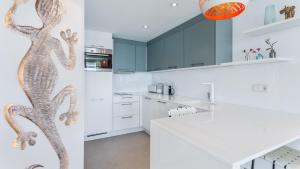a kitchen with white countertops and a mural of a snake at The Hype Beachhouse in Playa de Palma