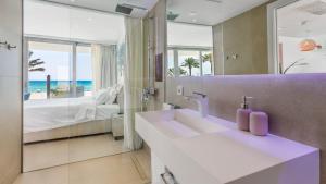 a bathroom with a sink and a bed and a mirror at The Hype Beachhouse in Playa de Palma