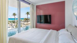 a bedroom with a large bed with a red wall at The Hype Beachhouse in Playa de Palma