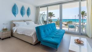 a bedroom with a bed and a blue chair at The Hype Beachhouse in Playa de Palma